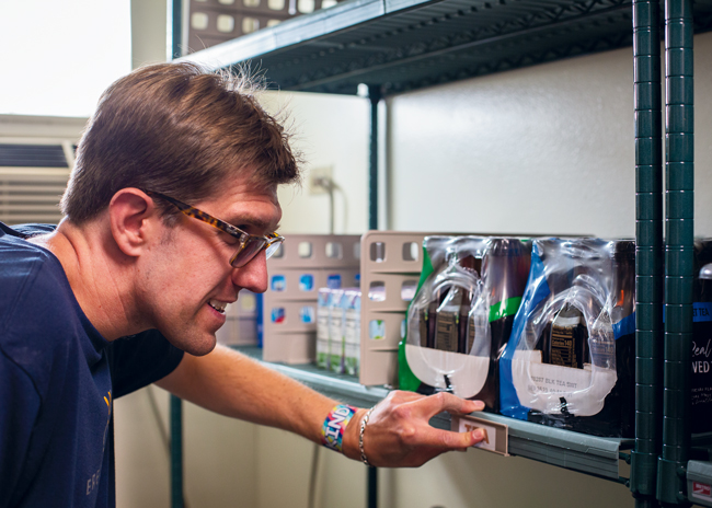 Alex Randall reads the new Braille labels in the reconfigured storage room. 
