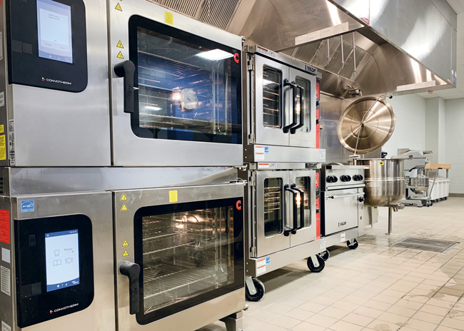 As foodservice kitchens shrink, vertical stacking of combis and other equipment makes every square foot usable.  Photo courtesy of Rapids Contract Foodservice and Design