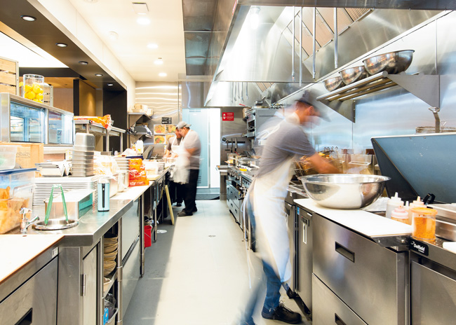 Some operators see undercounter  refrigeration equipped with doors instead of drawers as an extra  expense they can’t afford, but speed and ease of use for kitchen workers make them well worth the money in high-volume kitchens.  Photo courtesy of Rapids Contract Foodservice and Design