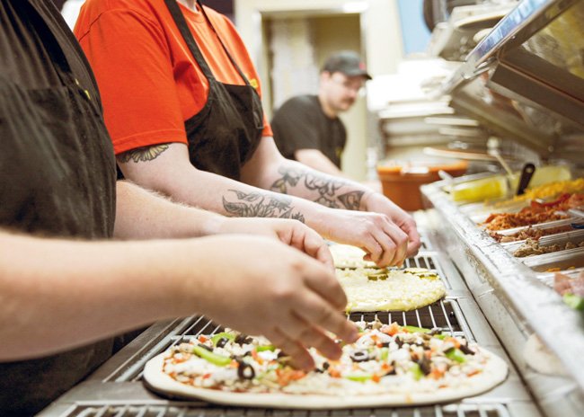Each day, staff at Toppers Pizza make pizza dough fresh in-store using 60-quart mixers, and they use the walk-in cooler to proof it. Dough sheeters were added to the brand’s equipment package a few years ago. 