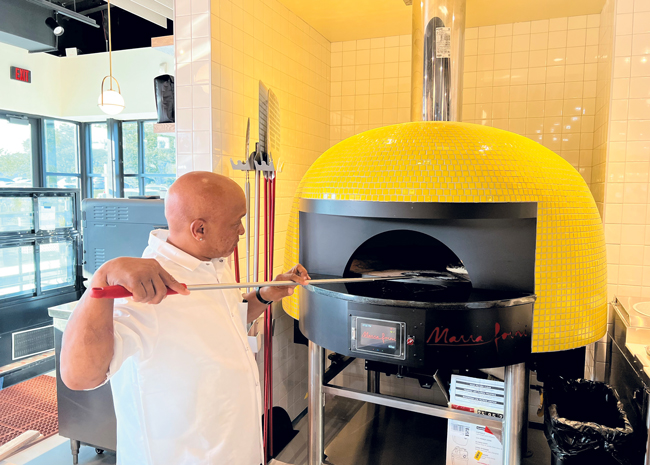 : A display oven, tiled in Rally Pickleball’s signature bright yellow, is the focal point of the pizza cafe in the main building.  Photos courtesy of Culinary Advisors, photo by Amanda Anderson