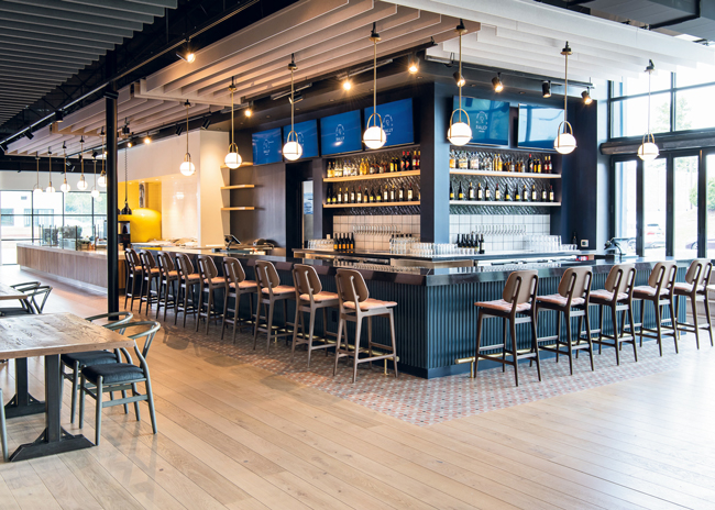 In a former warehouse in Charlotte, N.C., a large primary bar became a focal point of the Rally Pickleball entertainment complex. 